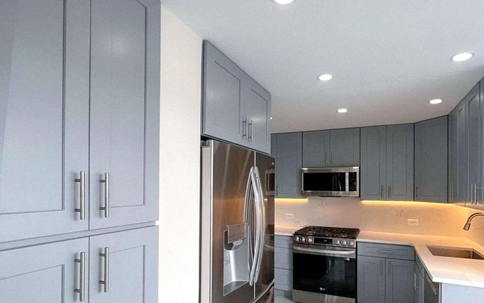 Gray shaker kitchen with quartz counters and marble backsplash in a Lenox Hill co-op, Upper East Side Manhattan