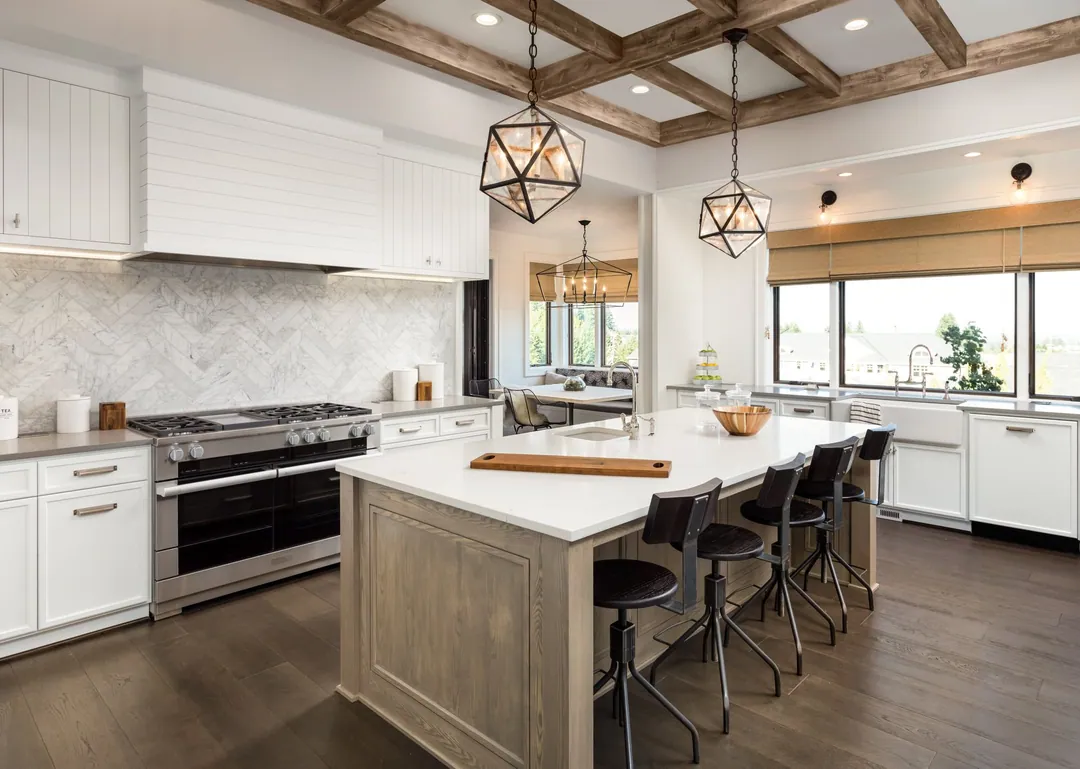 Open-plan kitchen renovation with reclaimed wood ceiling beams, herringbone backsplash and a wood island